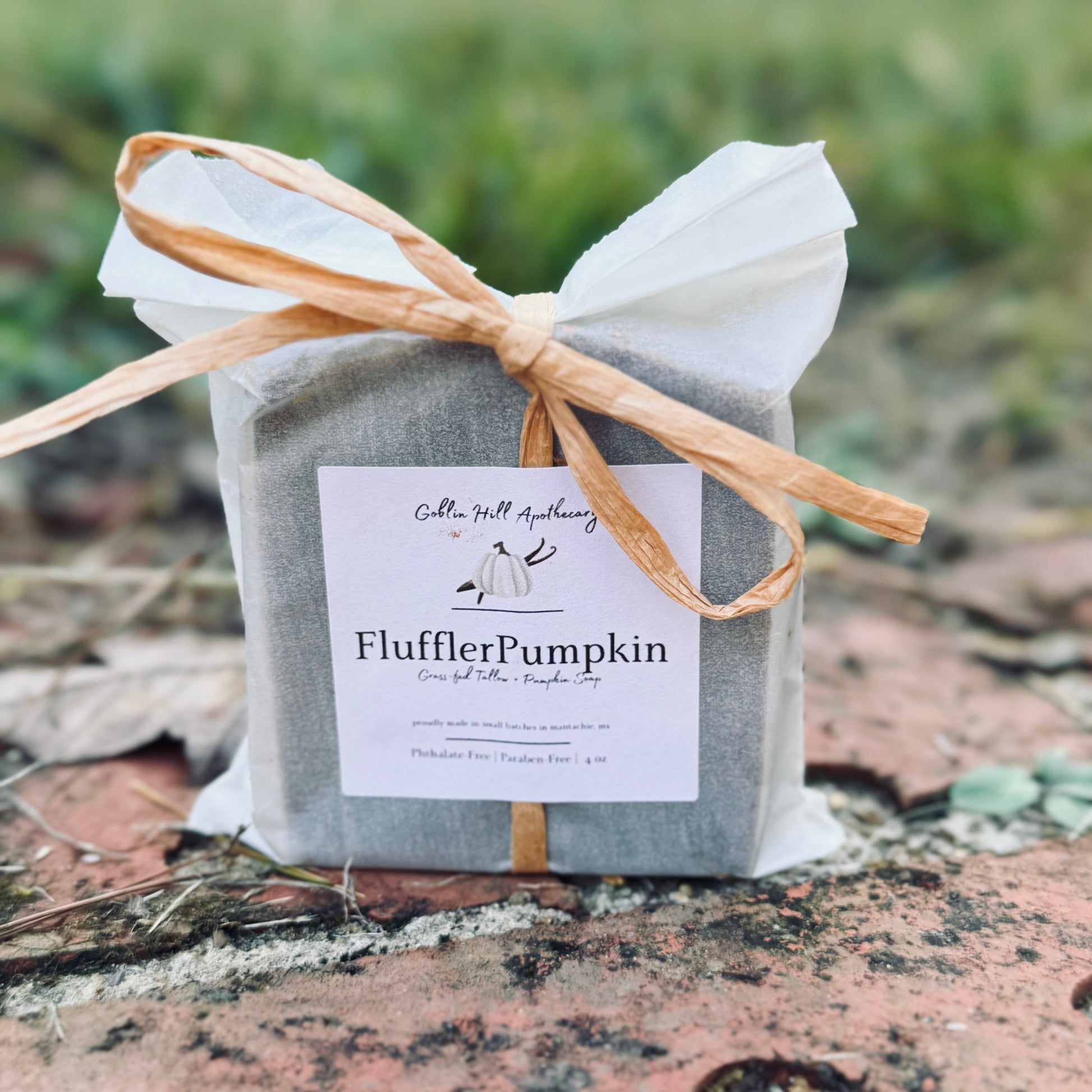 Gray package with a bow and 'FlufflerPumpkin' label on a natural background