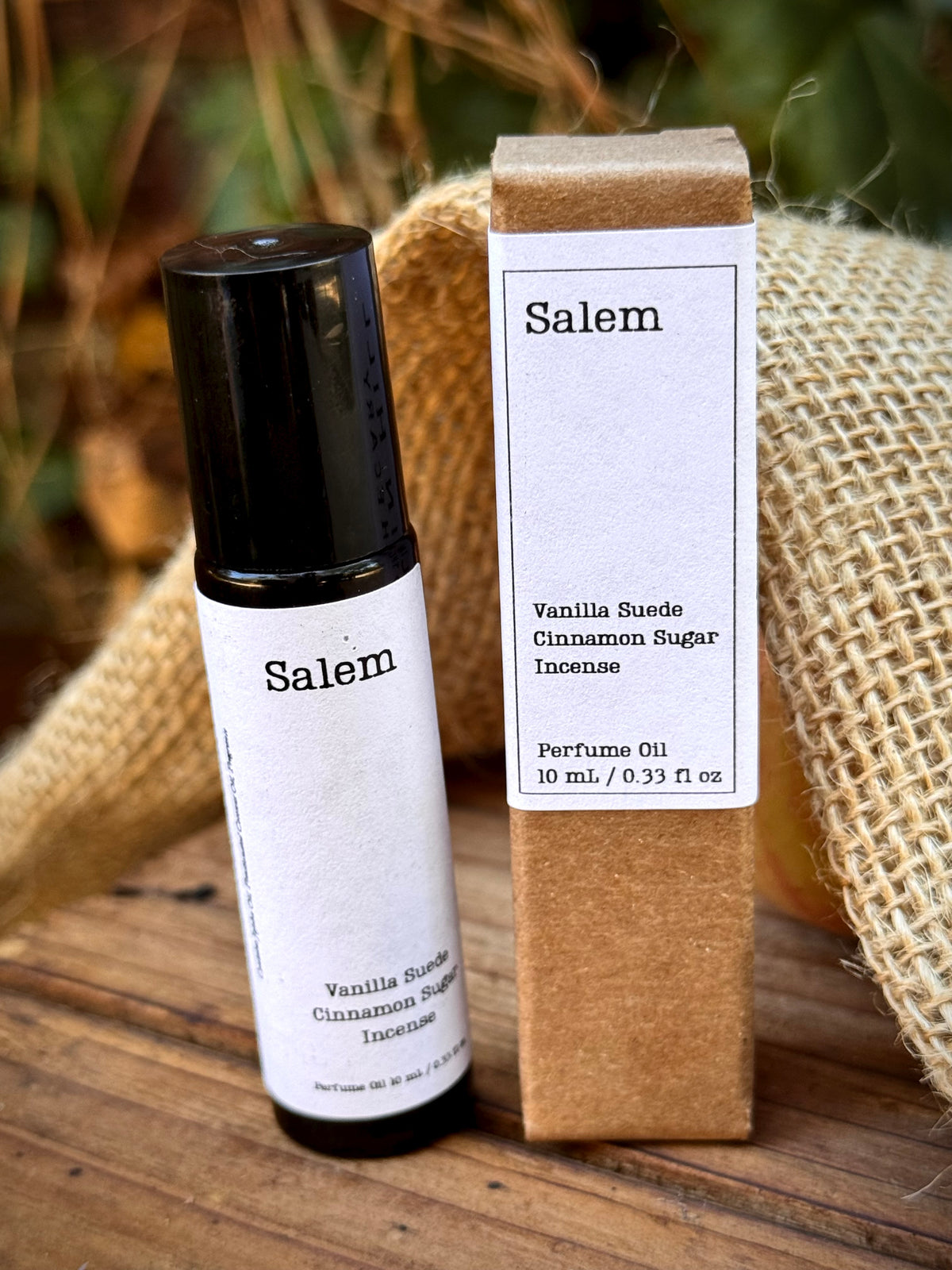 perfume roller bottle with white label next to a brown box that reads Salem