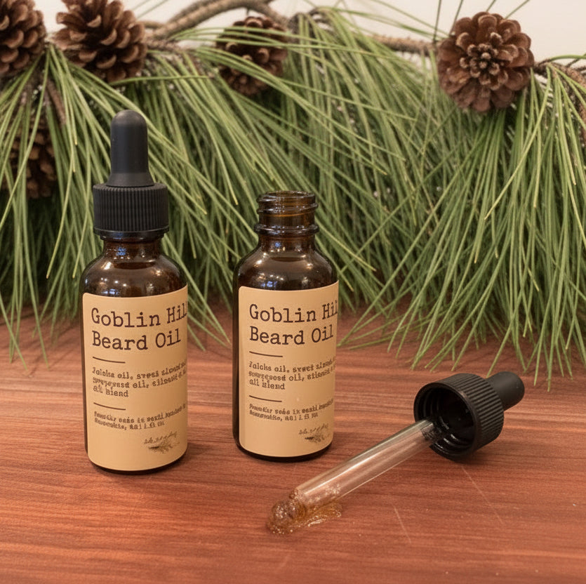 Two bottles of Goblin Hill Beard Oil on a wooden surface with a dropper.