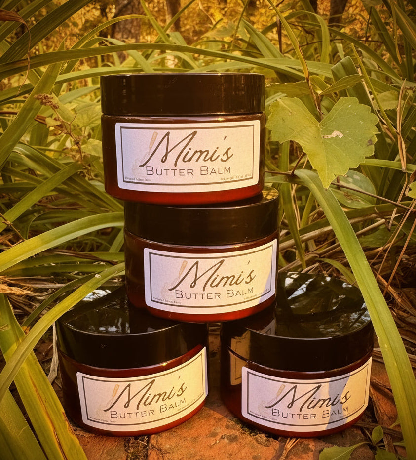 Jars of Mimi's Butter Balm stacked among greenery