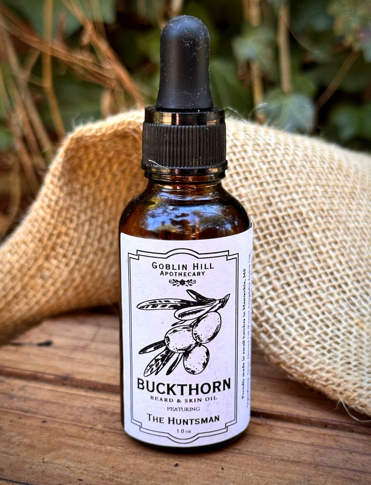Close up of an amber dropper bottle of buckthorn beard oil