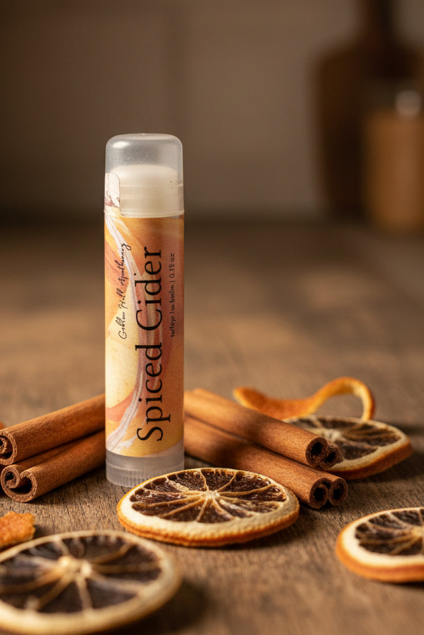 Stick of lip balm surrounded by dried oranges and cinnamon sticks