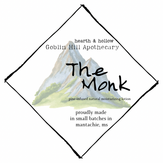 Product label for 'The Monk' lotion from Goblin Hill Apothecary with mountain graphic and text.