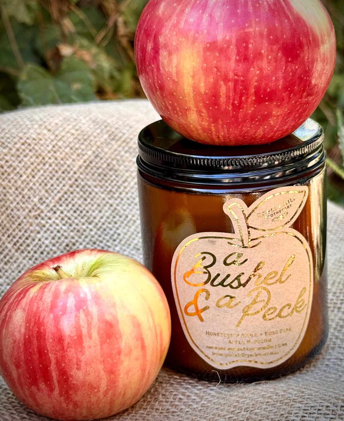 candle jar surrounded by apples