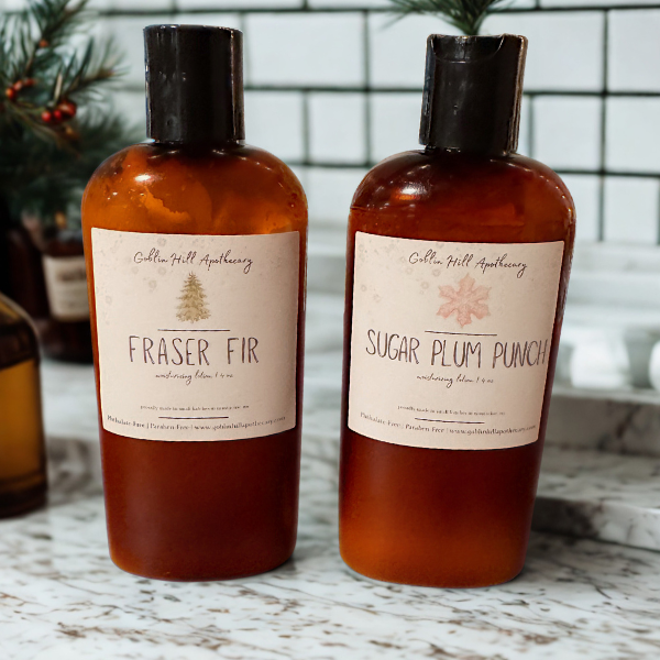 Two bottles of Goblin Hill Apothecary products on a marble surface with a blurred background.
