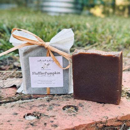 Bar of soap and wrapped product with 'FlufflerPumpkin' label on a natural background