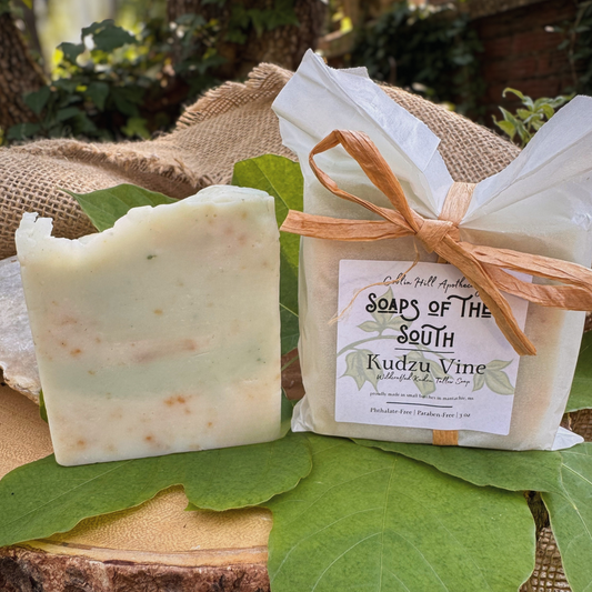 Bar of soap and wrapped soap on green leaves with a natural background