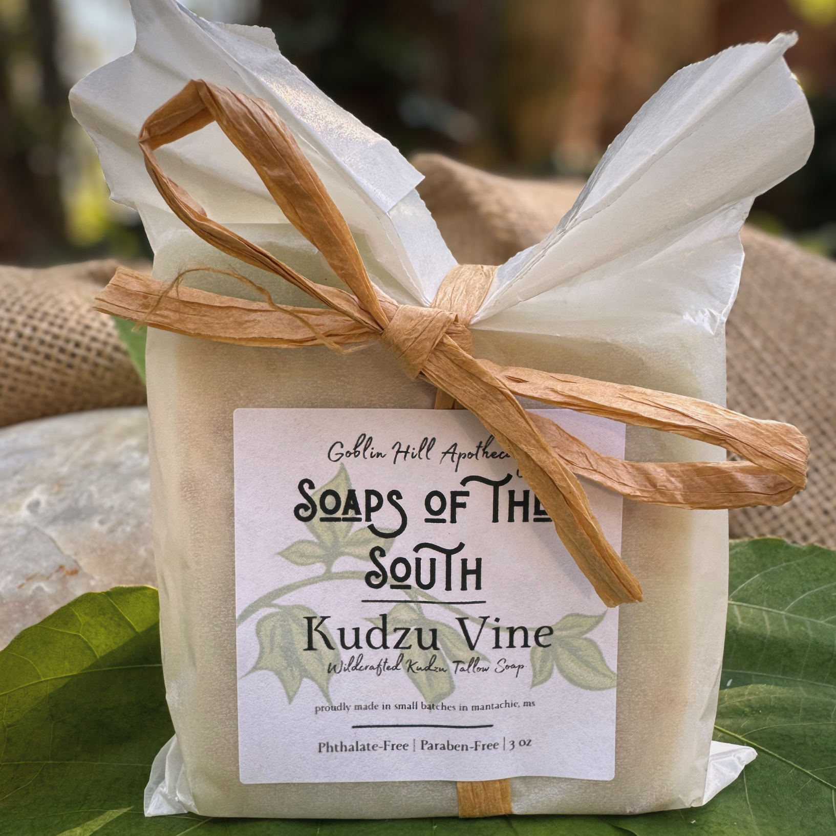 Soap package with a label on a green leafy background